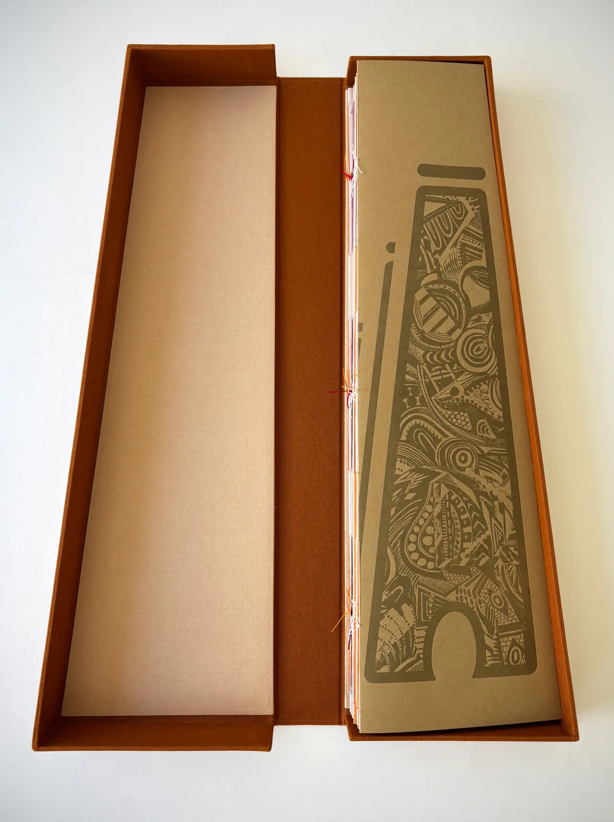The screen-printed clamshell box, its assembled spines reconstructing the silhouette of a tower